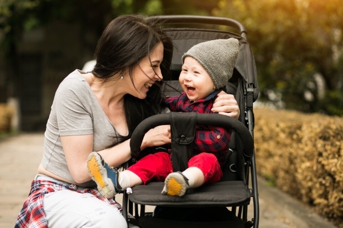 Ilustrasi ibu dan bayi yang menggunakan stroller di ruang terbuka