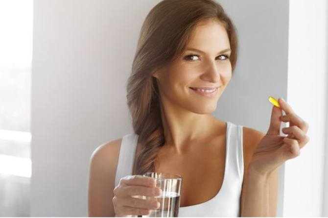 ilustrasi perempuan minum vitamin E untuk kesehatan
