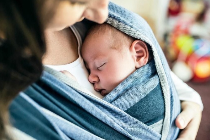 ibu menggendong bayi dengan gendongan yang aman