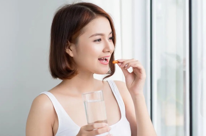 perempuan mengonsumsi vitamin mata