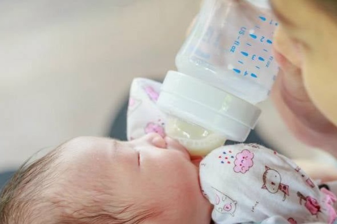Bayi minum dari botol yang sudah dihangatkan di bottle warmer