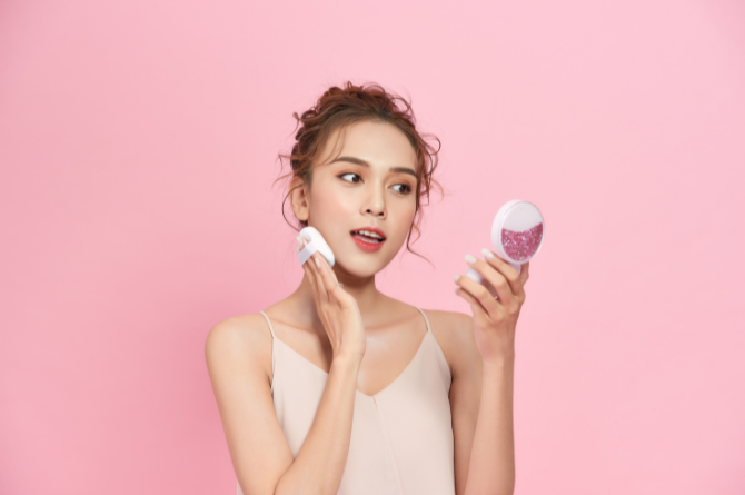 Perempuan menggunakan cushion untuk makeup