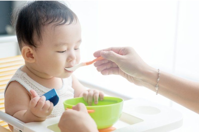 ilustrasi bayi makan MPASI pertama