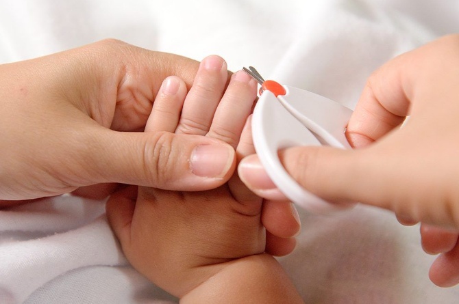 Bunda menggunting kuku bayi menggunakan gunting kuku khusus